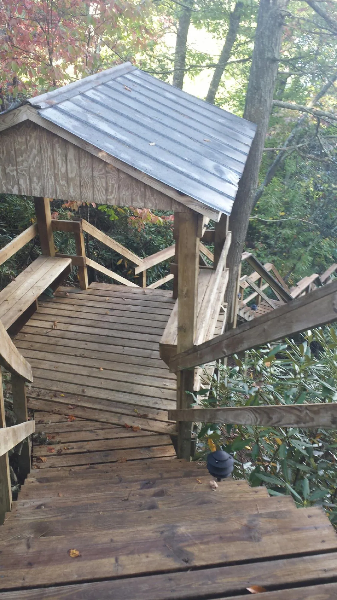 Metal roofed shelter over wooden steps on a wooded walkway — Skylight Repair & Installation work by our crew in Framingham
