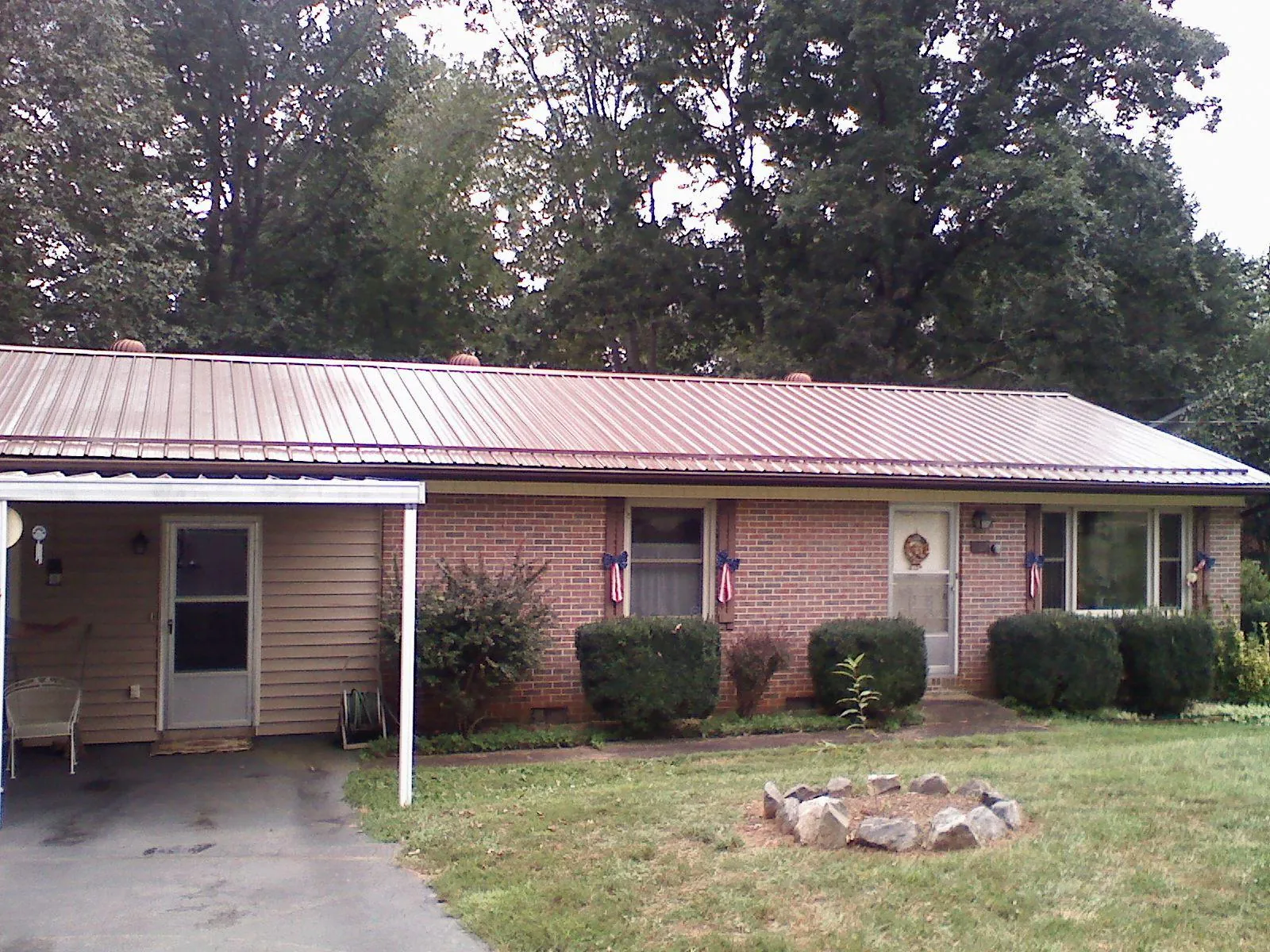 Bronze metal roof and carport on a brick ranch home — Roof Repair work by our crew in Framingham